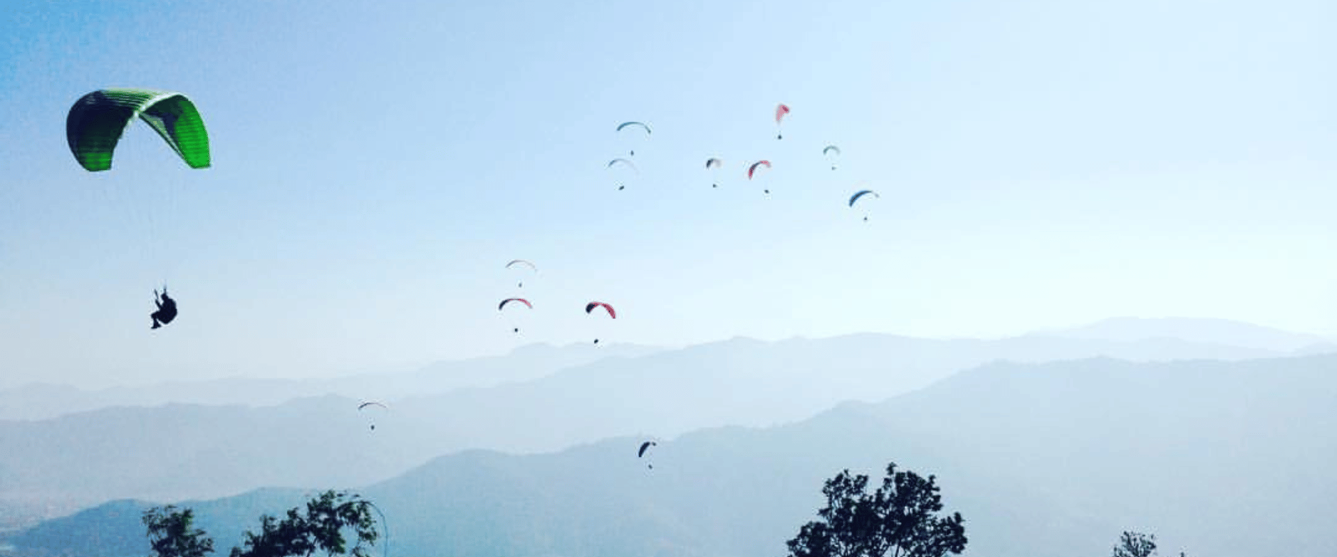 A picture Showing dhampus sarangkot trek with paragliding with beautiful scenerio at background